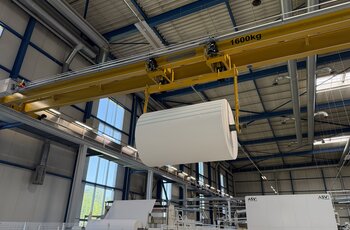 The two electric chain hoists of the overhead crane work together to lift the load beam carrying the paper roll.
