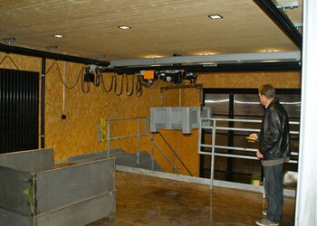 Ein Kunststoffgebinde wird vom GIS Elektrokettenzug schonend angehoben und vom Parterre zur Bühne im ersten Stock transportiert
