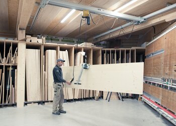 Elektrokettenzug zusammen mit Plattengreifer zum Heben von Holzplatten