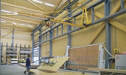 Konsolkran mit Vakuumheber für Plattentransport In einer Schreinerei werden Holzplatten mittels Kransystem befördert