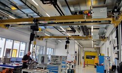 Hallenkran für maximale Hubhöhe Maschinenbauteile werden mit dem Laufkran auf die Werkbank gehoben