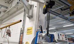 Mittels Vakuumheber wird das Transportgut angebhoben und mittels Drehkran von einer Arbeitsstation zur nächsten gebracht.