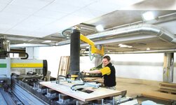 In Schreinerei werden Holzplatten mittels Drehkran befördert