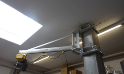 Arbeitskran mit Elektrokettenzug an Betonsäule befestigt