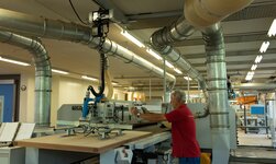 In Schreinerei werden Holzplatten mittels Vakuumheber auf die Sägemaschine gehoben