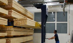 Holzbalken werden mit Kransystem in das Regal gehoben
